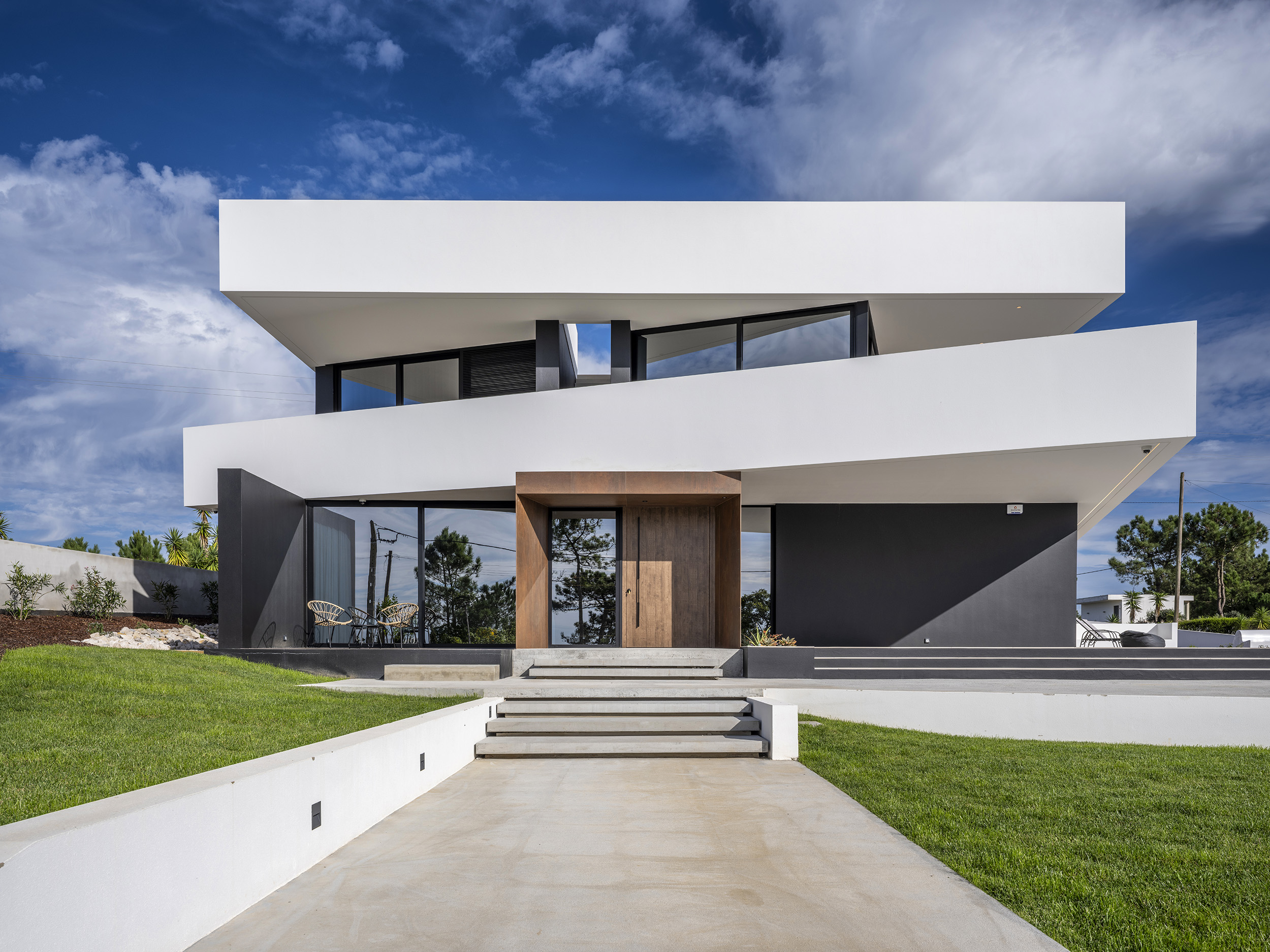 Fotografia de arquitetura residencial contemporânea em Paredes da Vitória, Portugal, destacando a clareza volumétrica, a relação entre interior e exterior, a luz natural e a materialidade do projeto.Projeto de habitação unifamiliar desenhado pelo arquiteto Nuno Morais e construído pela Pascal, integrando arquitetura de autor, paisagem e qualidade construtiva.Fotografia de arquitetura e interiores por Joas Souza, fotógrafo especializado em arquitetura contemporânea, design de interiores e projetos residenciais de alto nível em Portugal.